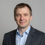 Портрет уверенного бизнесмена компании Като Рус на нейтральном фоне в студийном освещении